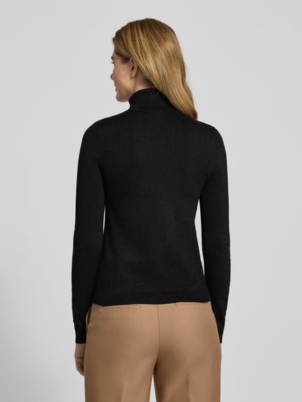 Frauenmodel trägt Slim Fit Rollkragenpullover aus Viskose-Mix Modell 'HAPPYSHINE' von Vero Moda, schwarz, schimmernd, Ganzkörperansicht Rückansicht