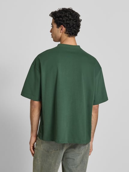 Männermodel trägt Oversized T-Shirt mit Rundhalsausschnitt von PROHIBITED aus reiner Baumwolle in dunklem Grün, Rückenansicht, Ganzkörperansicht Rückansicht.