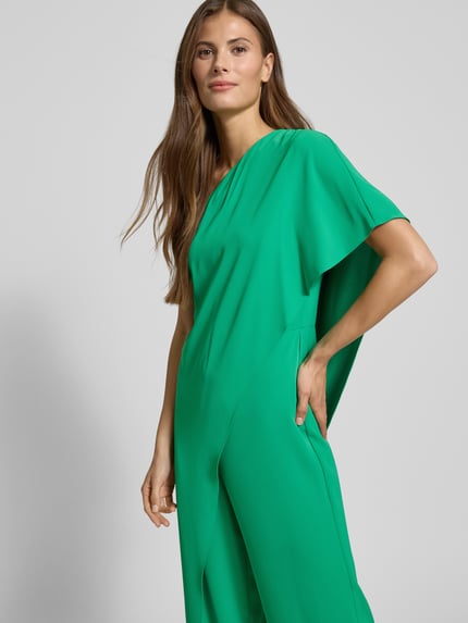 Frauenmodel trägt Jumpsuit mit Cape Modell 'April' von Lauren Ralph Lauren, One-Shoulder-Träger, gerader Schnitt, Ganzkörperansicht von vorne. Rückenlänge 50 cm, Brustweite 42 cm, Gesamtlänge 150 cm, Innenbeinlänge 85 cm, leuchtendes Grün, glatte Textur.