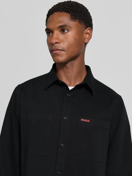 Männermodel trägt schwarze Straight Fit Hemdjacke aus Baumwolle Modell 'Egrin' von HUGO, Herren Hemdjacke, Nahaufnahme Oberkörper.