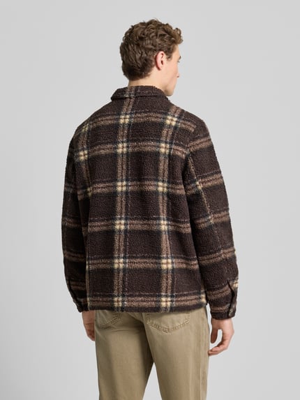 Männermodel trägt Hemdjacke mit Reißverschluss von Forét aus braunem Teddyfell mit Karomuster, Kentkragen, Regular Fit, Ganzkörperansicht Rückansicht