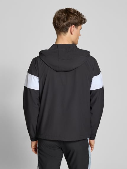Männermodel trägt Regular Fit Jacke mit Logo-Stitching Modell 'Caspio' von SERGIO TACCHINI in Schwarz mit weißen Details, Elastischer-Material-Mix, Kapuze mit Tunnelzug, Reißverschluss, Eingrifftaschen und elastische Ärmelabschlüsse, Rückenlänge 70 cm, Ärmellänge 68 cm, Ganzkörperansicht Rückansicht.