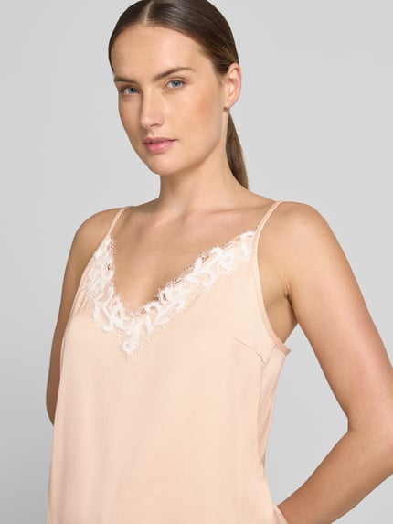 Kobieta prezentuje Blusentop mit Spitzenbesatz Model 'GIONA' od DRYKORN, Mieszanka materiałów z dodatkiem streczu, krój regular fit, cienkie ramiączka, dekolt w serek, obszycie koronką, Długość tyłu w rozmiarze 36: 33 cm, zbliżenie na górną część ciała.
