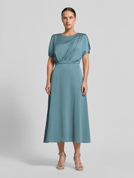 Frauenmodel trägt Midikleid aus Satin von SWING in Blau mit U-Boot-Ausschnitt, taillierter Passform und gelegten Falten, Ganzkörperansicht von vorne.