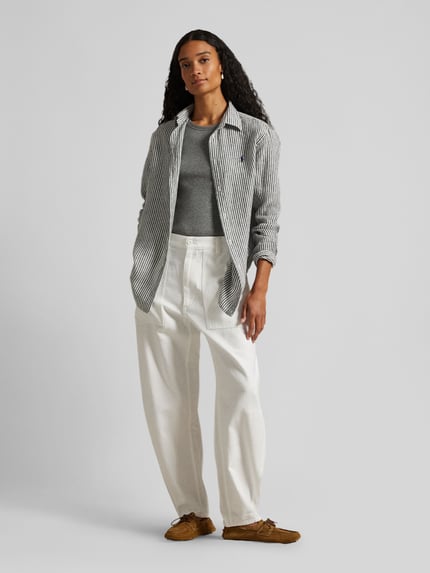 Frauenmodel trägt Tapered Stoffhose aus reiner Baumwolle von Polo Ralph Lauren in Weiß mit High Waist, Gürtelschlaufen, Ganzkörperansicht von vorne.