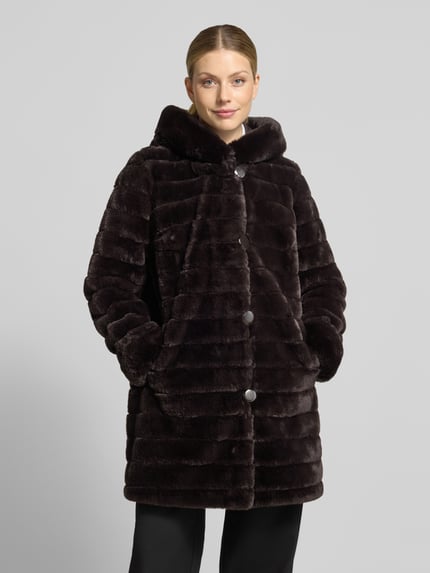 Frauenmodel trägt Regular Fit Mantel mit Wendefunktion und Webpelz-Innenseite von PETITE M., dunkelbraune Farbe, Knopfleiste, Eingrifftaschen, Ganzkörperansicht von vorne, Rückenlänge 85 cm, Schulterbreite 39 cm, Brustweite 50 cm, Ärmellänge 62 cm.