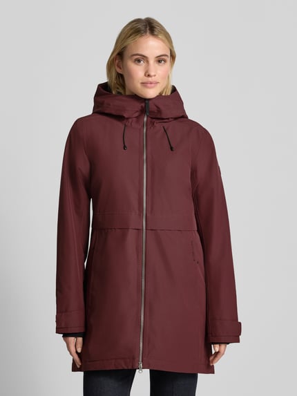 Frauenmodel trägt Regular Fit Parka mit Kapuze von Didriksons in Dunkelrot, Zweiwege-Reißverschluss, Eingrifftaschen, Ganzkörperansicht von vorne. Rückenlänge 87 cm, Schulterbreite 41 cm, Brustweite 48 cm, Ärmellänge 55 cm.