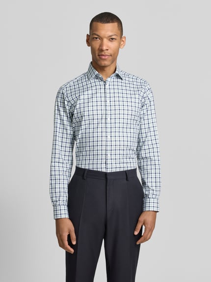 Männermodel trägt Regular Fit Business-Hemd mit Kentkragen von Christian Berg Men, kariertes Muster, Reine Baumwolle, Ganzkörperansicht von vorne. Rückenlänge 78 cm, Schulterbreite 47 cm, Ärmellänge 65 cm, Knopfleiste, Sportmanschetten, abgerundeter Saum, Größe 39/40.