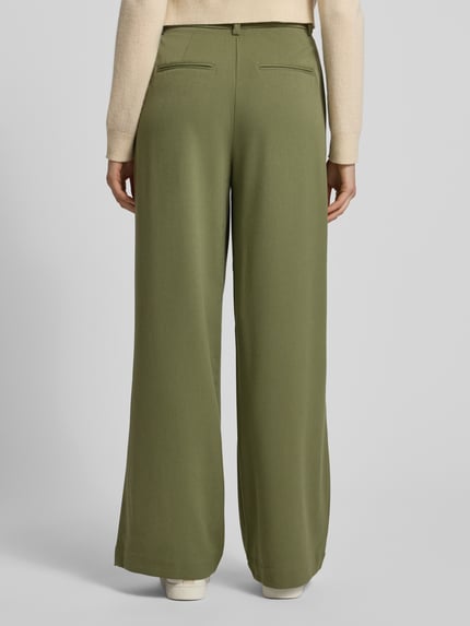 Vrouwenmodel draagt Stoffhose mit Gesäßtaschen Modell 'Henrika' van MSCH Copenhagen, los vallende pasvorm, achterkant volledig zichtbaar.