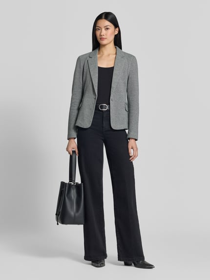 Vrouwenmodel draagt Slim Fit Kurzblazer met katoenmix model 'JULIA' van VERO MODA in lichtgrijs, gecombineerd met zwarte broek en tas, full-body frontale aanzicht