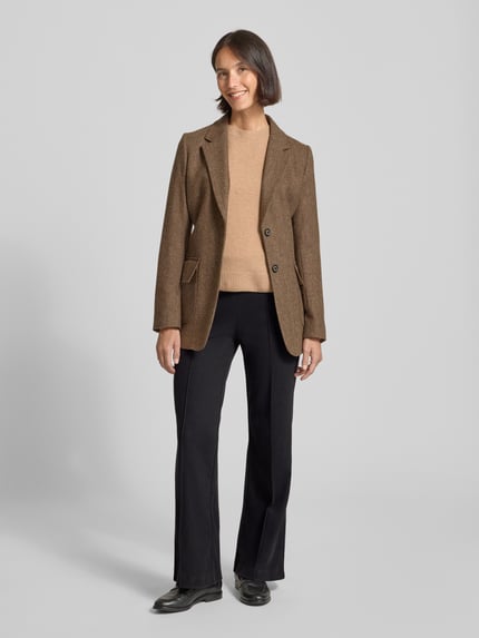 Vrouwenmodel draagt Flared Stoffhose mit fixierten Bügelfalten van Christian Berg Woman, zwart, viscosemix, wijd uitlopend, vooraanzicht.