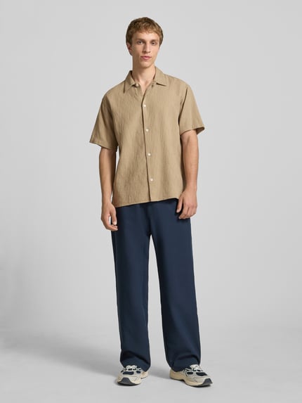 Männermodel trägt Regular Fit Freizeithemd mit Strukturmuster Modell 'MONTAUK' von Jack & Jones, beige, reine Baumwolle, Ganzkörperansicht von vorne.