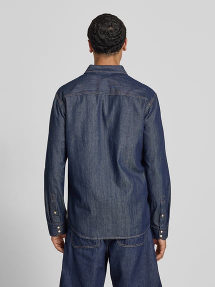 Männermodel trägt dunkelblaues Slim-Fit Freizeithemd mit Kentkragen Modell 'ESHERIDAN' von JACK & JONES, Reine Baumwolle, Ganzkörperansicht Rückansicht.