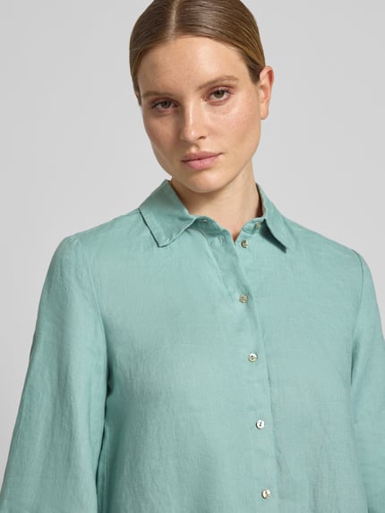 Frauenmodel trägt Relaxed Fit Leinenbluse mit 3/4-Arm von Christian Berg Woman in Mintgrün, Hemdblusenkragen, Knopfleiste, reine Leinenstruktur, Ganzkörperansicht von vorne. Rückenlänge 65 cm, Ärmellänge 48 cm, Größe 36.