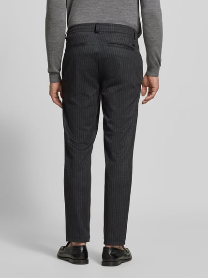 Männermodel trägt Regular Fit Stoffhose mit Viskose-Anteil Modell 'Phil' von Brax, dunkles Allover-Streifenmuster, Ganzkörperansicht Rückansicht.