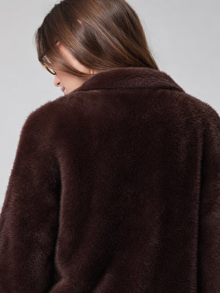 Frauenmodel trägt Regular Fit Pullover mit Baumwoll-Anteil von Jake*s aus der Jake*s Collection in Dunkelbraun, weiche Teddy-Textur, Nahaufnahme Rückansicht.