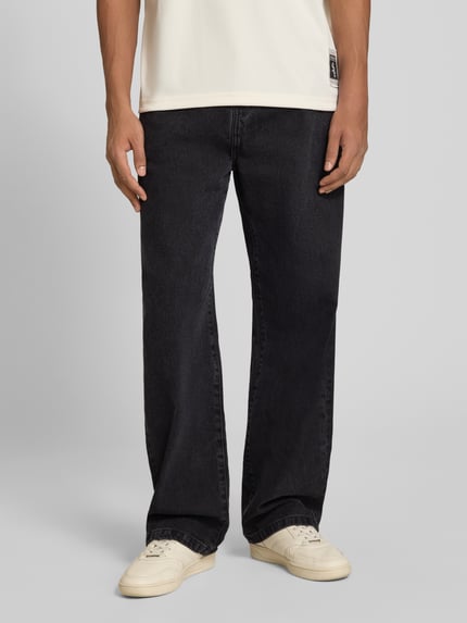 Männermodel trägt Straight Fit Jeans Modell 'LANDON' von Carhartt Work In Progress, dunkler Farbton, 5-Pocket-Design, Nahaufnahme Unterkörper. Herren Jeans, Material-Mix mit Baumwoll-Anteil, Knopf- und Reißverschluss, Bundweite bei Größe 32: 43 cm, Innenbeinlänge: 78 cm.