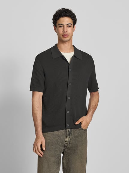 Męski model nosi Regular Fit Freizeithemd aus reiner Baumwolle od Marc O'Polo Denim, efekt: jednolity kolor, krój regular fit, naszywka z logo, kołnierzyk polo, dekolt w serek, listwa guzikowa, krótki rękaw, zakończenia prążkowane, wykończenie materiału: dzianina, 100% bawełna, kolor ciemny, tekstura prążkowana, przód, całe ciało.