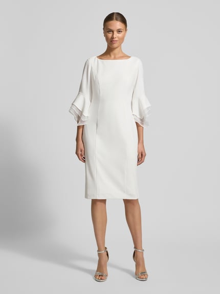 Frauenmodel trägt Cocktailkleid mit Rundhalsausschnitt von Adrianna Papell, Material-Mix mit Stretch-Anteil, taillierter Schnitt, 1/2-Ärmel, Nahtreißverschluss, Rückenlänge 100 cm, Brustweite 46 cm, Ärmellänge 49 cm, Farbe Weiß, glatte Textur, Ganzkörperansicht von vorne.