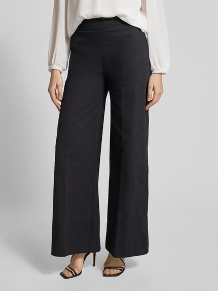 Frauenmodel trägt Hose mit elastischem Bund und Eingrifftaschen von Rinascimento, Baumwoll-Mix, weites Bein, Farbe Schwarz, Nahaufnahme Unterkörper.