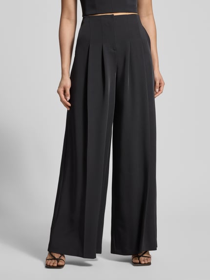 Vrouwenmodel draagt Stoffhose mit weitem Bein und gelegten Falten van Jake*s Cocktail, zwart, soepel vallende stof, wijde pijpen, Nahaufnahme onderlichaam, voorkant.