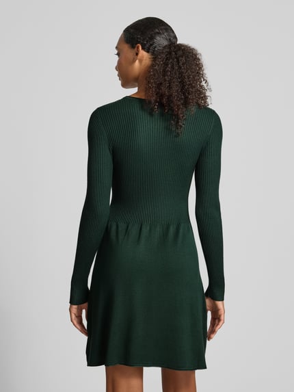 Frauenmodel trägt Regular Fit Strickkleid aus Viskose-Mix Modell 'ALMA' von ONLY in Dunkelgrün, feine Rippstruktur, Damen Strickkleid, Ganzkörperansicht Rückansicht.
