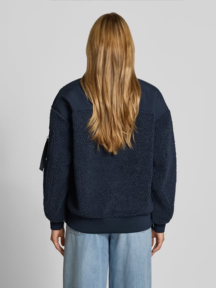 Frauenmodel trägt Teddyjacke mit Stehkragen Modell 'Emeline' von MOS MOSH in Dunkelblau, lockere Passform, Rückenansicht.