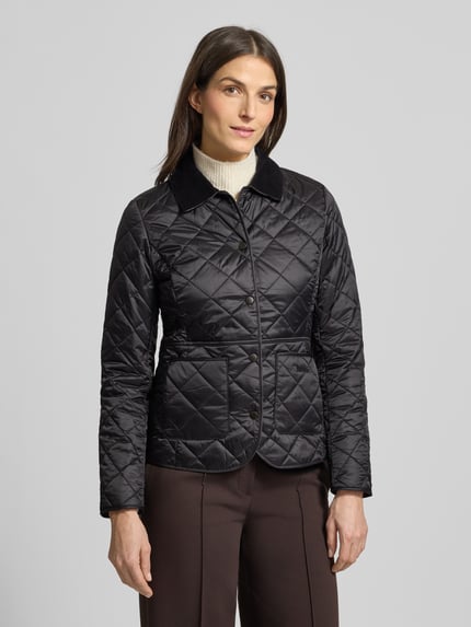 Frauenmodel trägt Steppjacke mit Cordkragen Modell 'Deveron' von Barbour, taillierter Schnitt, Logo-Stickerei, Ganzkörperansicht von vorne.