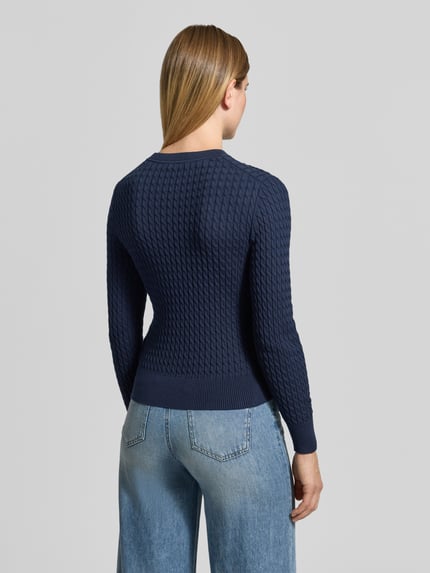 Vrouwenmodel draagt Regular Fit Pullover aus reiner Baumwolle van Tommy Hilfiger, donkerblauw met geribbelde textuur, volledig beeld van achteren.