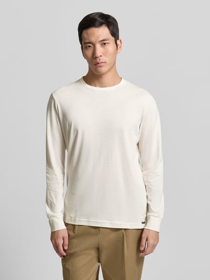 Männermodel trägt Regular Fit Langarmshirt aus reiner Baumwolle von Tom Tailor, unifarben, Rundhals, Jersey, Ganzkörperansicht von vorne.