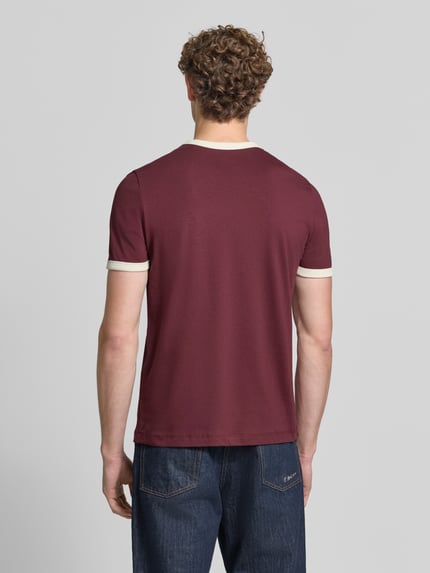 Männermodel trägt Regular Fit T-Shirt aus reiner Baumwolle von MCNEAL in Dunkelrot mit kontrastivem Rundhalsausschnitt und Ärmelumschlägen, Rückenansicht, Ganzkörperansicht Rückansicht. Rückenlänge bei Größe M: 68 cm.