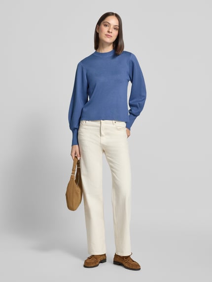 Frauenmodel trägt Pullover mit langen Bündchenärmeln Modell 'K106-comppleat' von JAKE*S WOMAN COLLECTION in matt unifarbenem Blau, Struktur-Strick, Rippen an Saum und Ärmeln, Ganzkörperansicht von vorne.