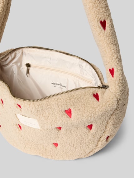 Produktfoto, beige Schultertasche aus Teddyfell mit roten Herzen, Reißverschluss und Logo-Patch, Shoulder Bag mit Teddyfell Modell 'Hearts' von STUDIO NOOS, Hauptfach, Innenfach, Maße 42x21x13 cm, Schulterriemen 43 cm
