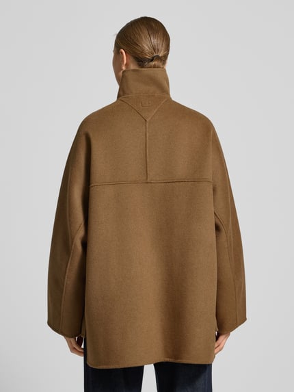 Vrouwenmodel draagt Oversized Mantel aus Woll-Mix van Tommy Hilfiger in effen bruin, lange mouwen, asymmetrisch, rugaanzicht, filztextuur.