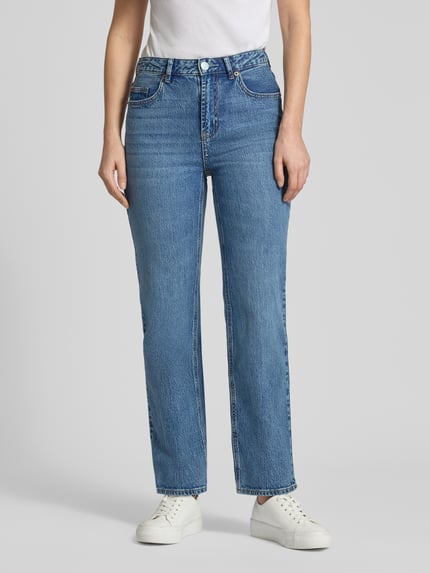 Kobiece modelka nosi Straight Fit Jeans aus Baumwoll-Mix Modell 'TESSA' od Vero Moda, niebieski denim, pięciokieszeniowy fason, wysoki stan, przedni widok pełnej sylwetki.