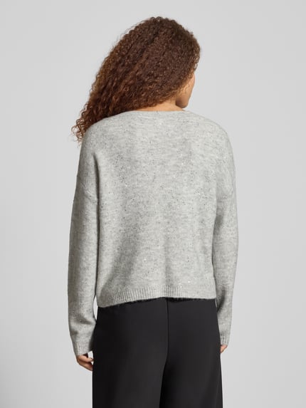 Frauenmodel trägt Regular Fit Strickpullover mit Paillettenbesatz Modell 'ARIZONA' von Only in Melange-Optik, Ganzkörperansicht Rückansicht.