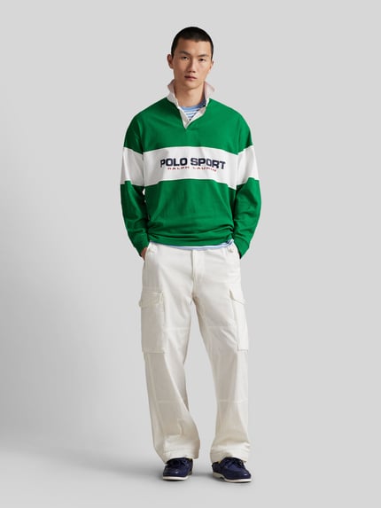 Männermodel trägt Regular Fit Poloshirt aus reiner Baumwolle von Polo Ralph Lauren, grün-weiß, langarm, Piqué-Struktur, Ganzkörperansicht von vorne.