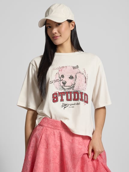 Frauenmodel trägt Regular Fit T-Shirt aus reiner Baumwolle von Jake*s Casual in Creme mit Print und rotem Schriftzug, Nahaufnahme Oberkörper.