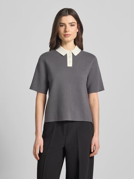 Vrouwenmodel draagt gebreid shirt van Someday, materiaalmix met viscose, recht model, polokraag, knoopsluiting, model 'Tipolo', grijs met crèmekleurige kraag, ruglengte maat 36: 54 cm, mouwlengte maat 36: 25 cm, vooraanzicht volledige lichaamsopname.