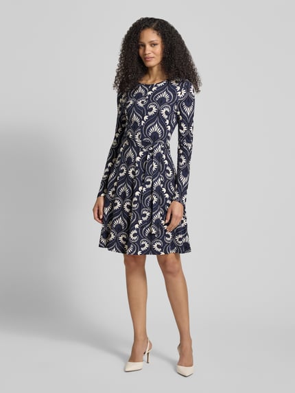 Vrouwenmodel draagt tailliertes Freizeitkleid aus Viskose-Mix Modell 'SAVANA' van Weekend Max Mara met all-over motief, midilengte, ronde hals, strikceintuur, lange mouw en rechte zoom, jersey materiaalverwerking, ganzkörperaanzicht van voren.