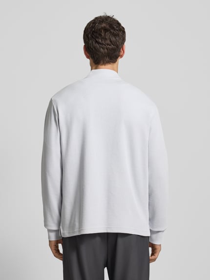 Männermodel trägt Regular Fit Sweatshirt aus Baumwoll-Mix Modell 'PE_HIVE' von BOSS Orange in unifarbener Optik mit Struktur-Muster, Ganzkörperansicht Rückansicht.