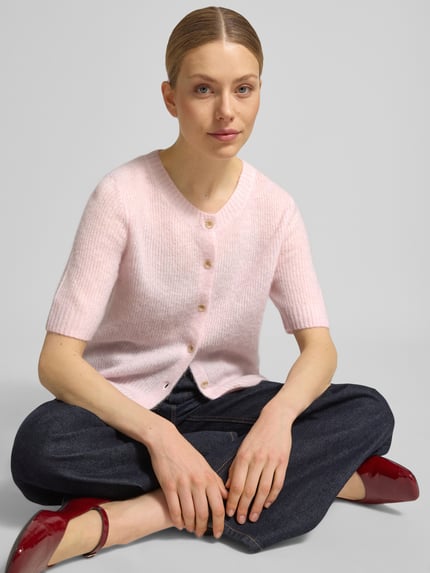Frauenmodel trägt Cardigan aus Woll-Mix mit 1/2-Arm Modell 'Thora' von MOS MOSH in zartem Rosa, feine Textur, Nahaufnahme Oberkörper.
