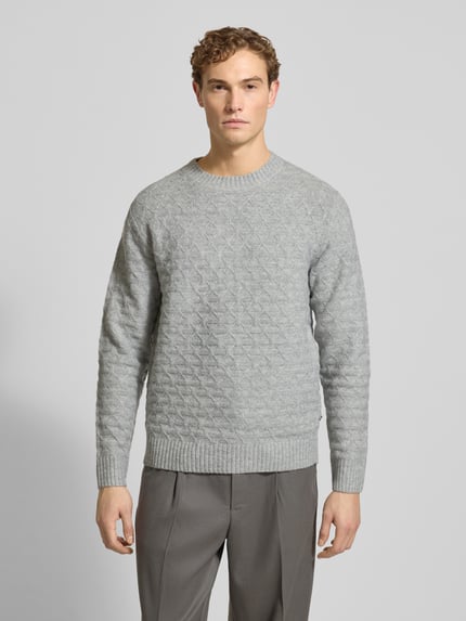 Męski model nosi szary Strickpullover mit gerippten Abschlüssen Modell 'BLASIMON' od Jack & Jones Premium, regular fit, widok całej sylwetki z przodu. Materiał z dodatkiem wełny, prążkowane wykończenia, okrągły dekolt.