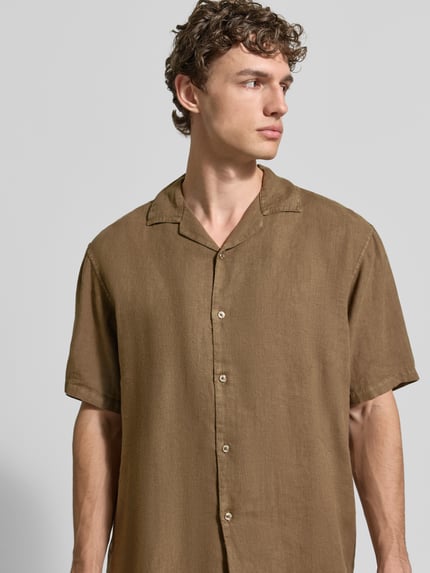 Männermodel trägt Regular Fit Leinenhemd mit Reverskragen von MCNEAL in Braun, Kurzarm, Knopfleiste, reine Leinen-Textur, Nahaufnahme Oberkörper.