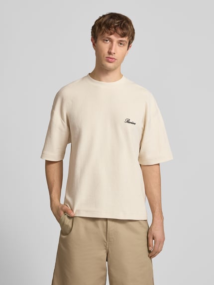 Männermodel trägt T-Shirt mit Rundhalsausschnitt und Label-Stitching von REVIEW in Beige, Relaxed-Fit, Baumwoll-Mix, Ganzkörperansicht von vorne, Rückenlänge bei Größe M 64 cm.