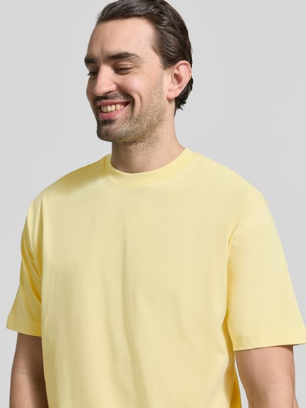 Männermodel trägt Regular Fit T-Shirt aus reiner Baumwolle von MCNEAL in Hellgelb, kurzärmelig, Rundhalsausschnitt, Nahaufnahme Oberkörper.