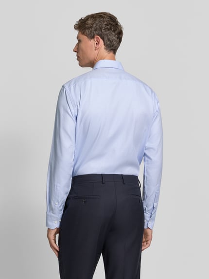 Männermodel trägt Regular Fit Businesshemd mit Kentkragen von BOSS in Hellblau, feines Webmuster, unifarben, Ganzkörperansicht Rückansicht.
