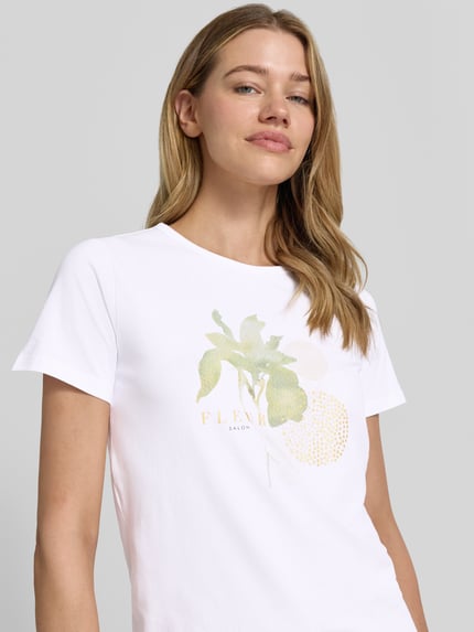 Vrouwenmodel draagt T-shirt met motiefprint model 'RINA' van Soyaconcept, mix van katoen en elastaan, regular fit, ronde hals, ruglengte maat S 63 cm, wit met groene en gele details, nahaufnahme bovenlichaam