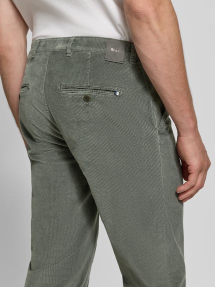 Männermodel trägt Modern Fit Cordhose aus Baumwoll-Mix Modell 'Fabio' von Brax in Olivgrün, schmale Passform, Herren Schmale Hose, Ganzkörperansicht Rückansicht