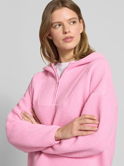 Frauenmodel trägt Hoodie aus Teddyfell Modell 'COZY' von Noisy May in Rosa, Regular Fit, mit Reißverschluss, Nahaufnahme Oberkörper.